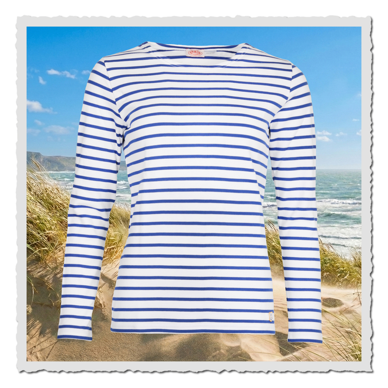 Gestreiftes Armor Lux Matrosenshirt in Weiß und Blau, leicht taillierte Damen-Passform, ärmellanges Shirt vor Dünenlandschaft.